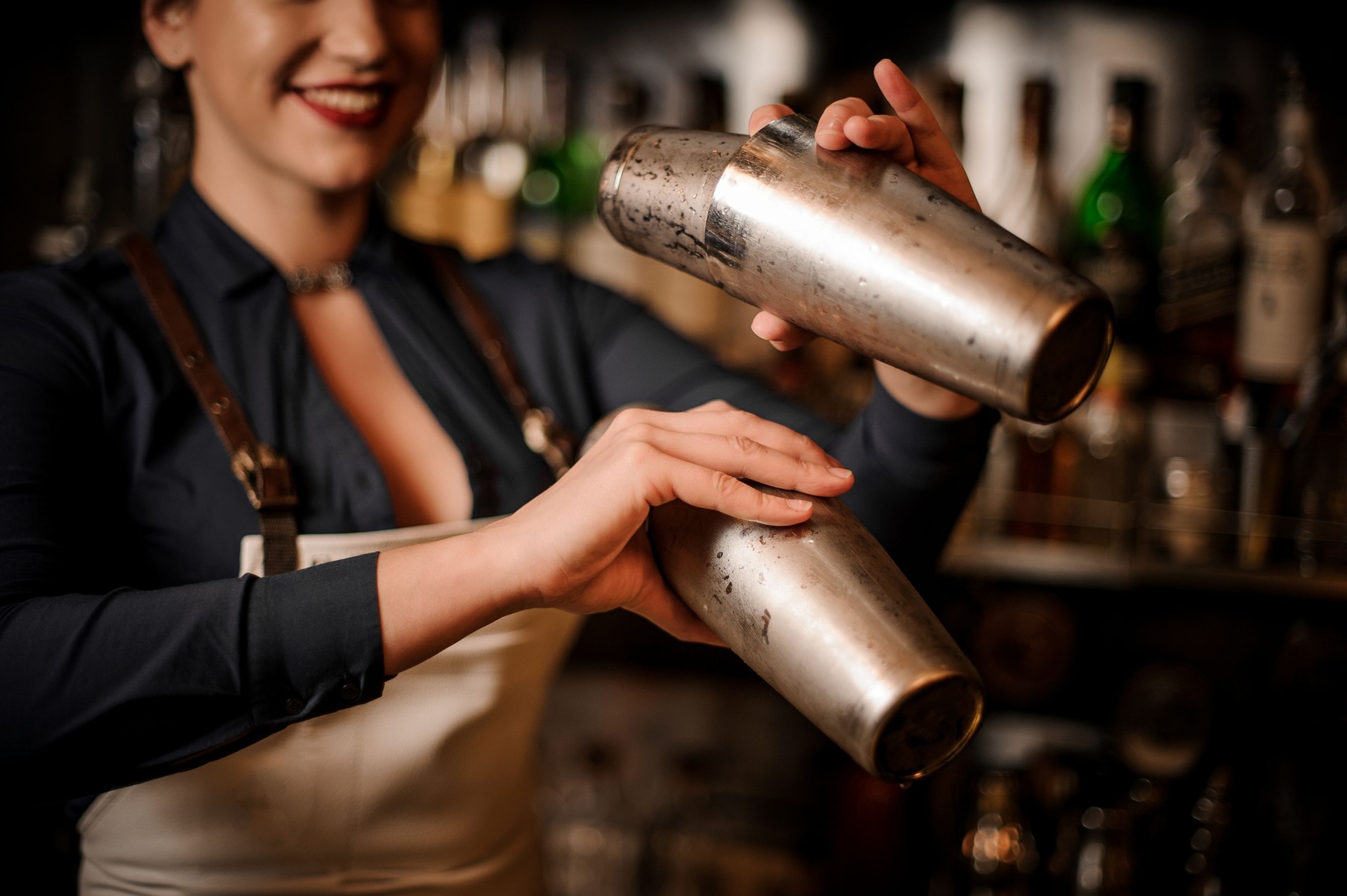 Schönes Lächeln auf den Lippen Bardame machen cocktail Shaker